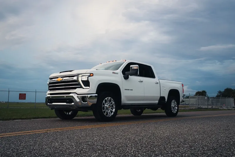 White Chevy Silverado 3500HD low front three-quarter on the road