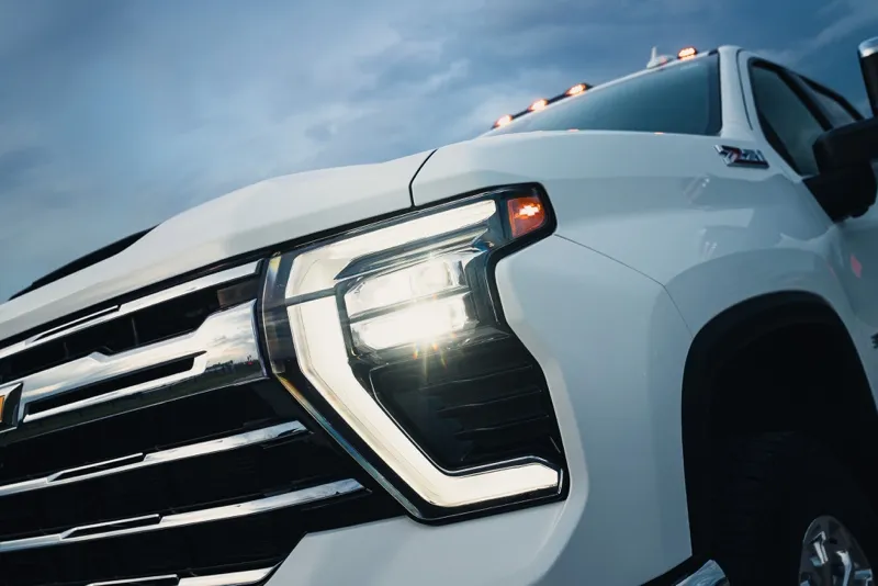 Headlight and grille of a white Chevy Silverado 3500HD