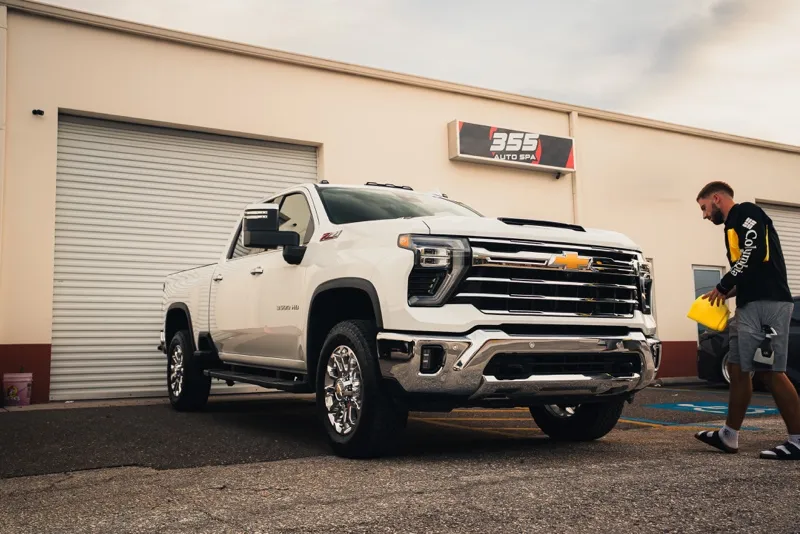 White Chevy Silverado 3500HD outside the 355 Auto Spa bay door