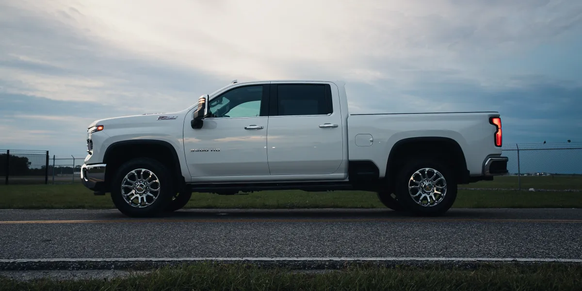 White Chevy Silverado 3500HD side profile under a stormy sky