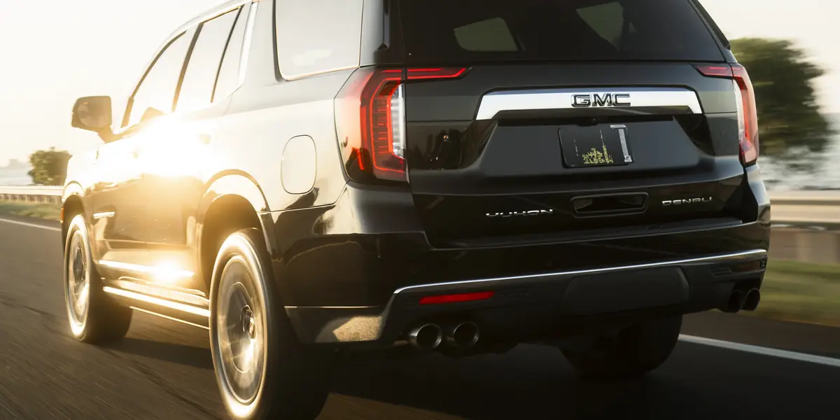 Black GMC Yukon Denali rolling shot at sunset