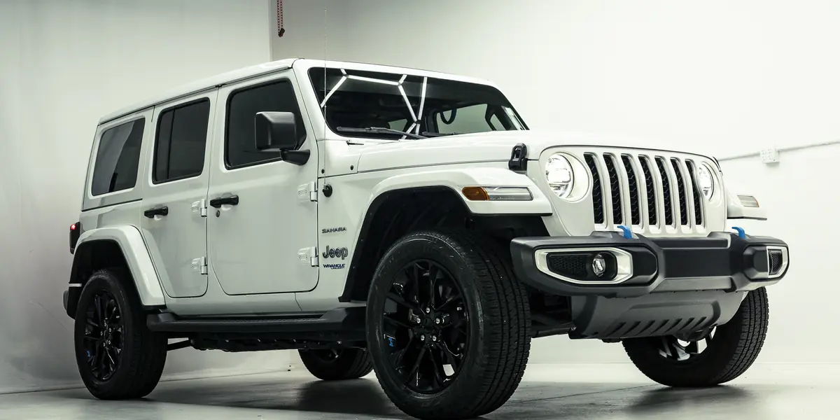 White Jeep Wrangler 4xe under the hex lights in the 355 Auto Spa studio