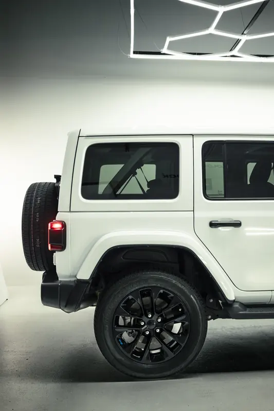 Jeep Wrangler 4xe rear quarter and black wheel after detailing