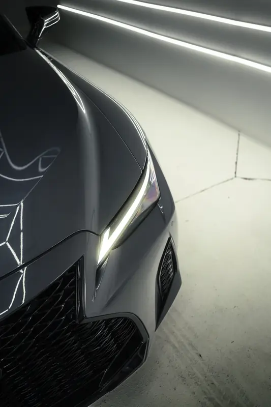 Lexus IS headlight and fender reflecting the studio lights