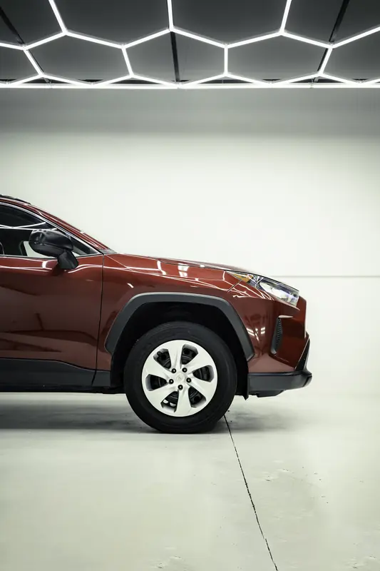 Red Toyota RAV4 nose and front wheel on a white background